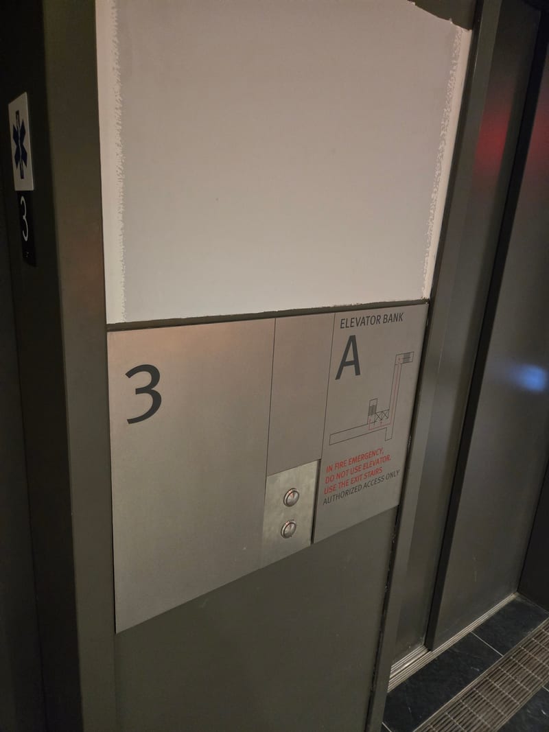 Elevator bank lobby ID sign with floor directory panel.